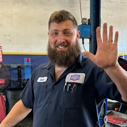 Matt Chavanne, Lead Technician of AAMCO in South Tampa, in the shop garage, stops to wave hello